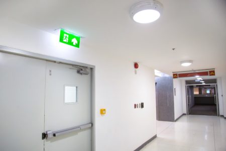 close-up-green-fire-exit-sign-with-door-exit